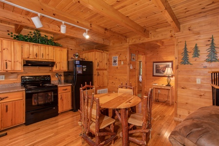 Dining space for four in the kitchen with black appliances at Dreams Do Come True, a 1-bedroom cabin rental located in Pigeon Forge