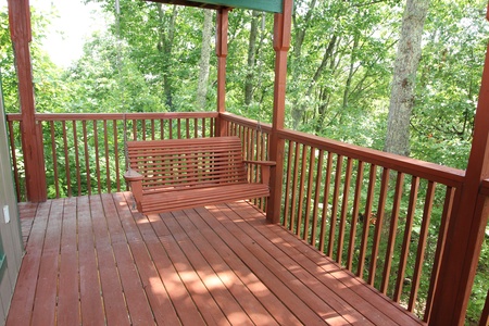 Swing on the deck at Bushwood Lodge, a 3-bedroom cabin rental located in Gatlinburg