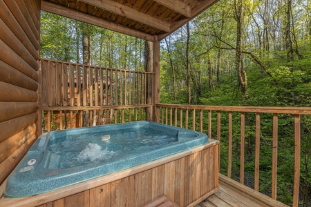 Hot tub on a covered deck with a privacy fence at A Cheerful Heart, a 2 bedroom cabin rental located in Pigeon Forge