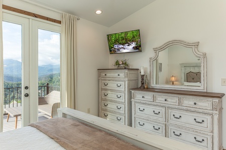 Dresser, chest of drawers, TV, and deck access at Mountain Celebration, a 4 bedroom cabin rental located in Gatlinburg