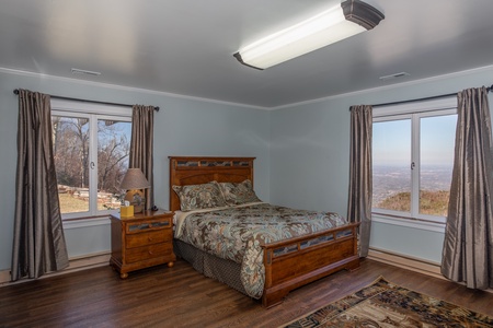 Bedroom with a large bed and nightstand at Best View Ever! A 5 bedroom cabin rental in Pigeon Forge