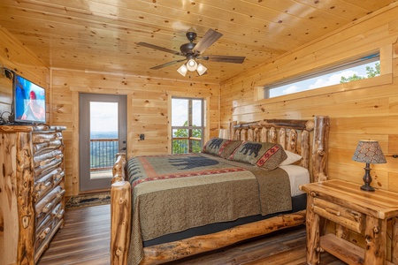 Bedroom with a TV, dresser, and deck access at 4 States View, a 2 bedroom cabin rental located in Pigeon Forge