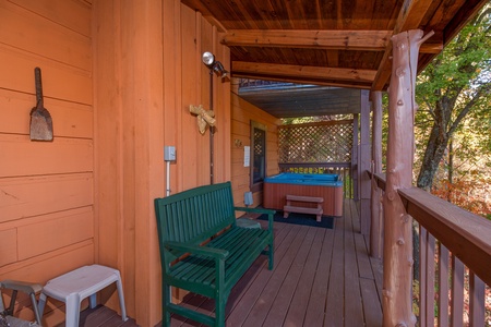 Deck with a bench and hot tub at Hawk's Nest, a 1 bedroom cabin rental located in Pigeon Forge