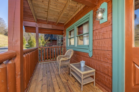 Front porch with a wicker chair and table A Beary Nice Cabin, a 2 bedroom cabin rental located in Pigeon Forge