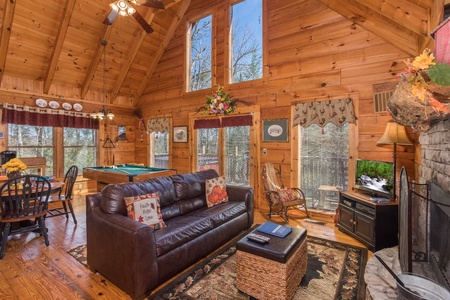 Living room with fireplace, tv, deck access, and vaulted ceilings at Cloud 9, a 1-bedroom cabin rental located in Pigeon Forge
