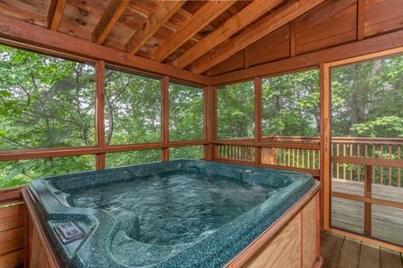Hot tub on a covered, screened-in porch at Cabin in the Clouds, a 3-bedroom cabin rental located in Pigeon Forge