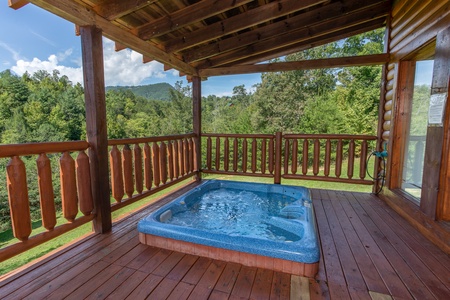 Hot tub on a covered deck at Cabin Fever, a 4-bedroom cabin rental located in Pigeon Forge