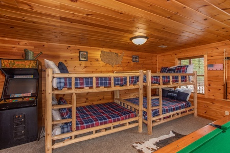 Two sets of full-sized bunk beds in the game room at Hibernation Station, a 3-bedroom cabin rental located in Pigeon Forge