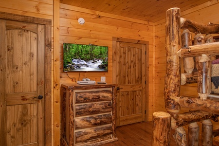 Bunk room with a dresser and TV at Four Seasons Palace, a 5-bedroom cabin rental located in Pigeon Forge