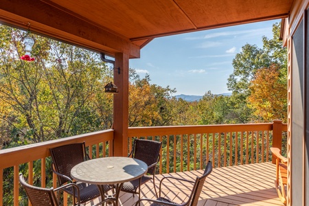 Covered deck with dining table for four at Lazy Bear Retreat, a 4 bedroom cabin rental located in Pigeon Forge