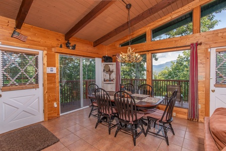 Dining space with seating for six and floor-to-ceiling windows at Bushwood Lodge, a 3-bedroom cabin rental located in Gatlinburg