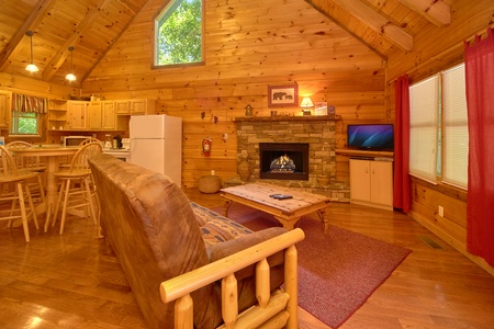 Living room with futon, fireplace, and TV at Wild Crush, a 1 bedroom cabin rental located in Pigeon Forge