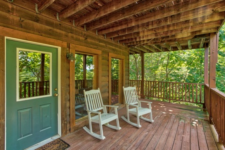 rocking chairs on a covered deck at angel's majestic view a 3 bedroom cabin rental located in pigeon forge