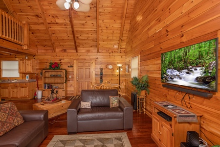 Oversized chair, king sleeper sofa, and large TV in the living room at Enchanted Evening, a 1 bedroom Pigeon Forge cabin rental