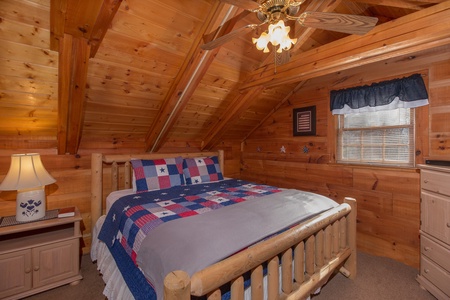 Bedroom with a log bed, night table, and lamp at Beary Good Time, a 1-bedroom cabin rental located in Pigeon Forge