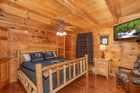 King bed and TV in a bedroom at Mountain Music, a 5 bedroom cabin rental located in Pigeon Forge