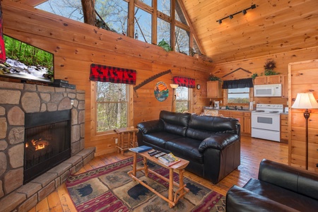 Fireplace, TV, and loveseat in a living roo mat Lumber Jack Lodge, a 1 bedroom cabin rental located in Gatlinburg