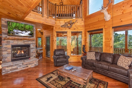 Living room with a stone fireplace and television at Four Seasons Palace, a 5-bedroom cabin rental located in Pigeon Forge