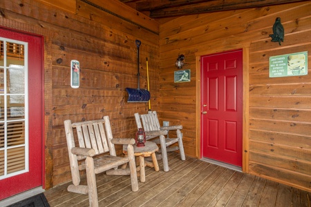 Side porch with two log chairs at Alpine Romance, a 2 bedroom cabin rental located in Pigeon Forge