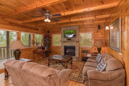 Living room with a fireplace and TV at Howlin' in the Smokies, a 2 bedroom cabin rental located in Pigeon Forge