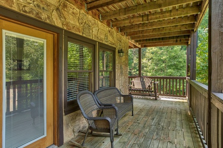 Rocker and benches on the covered porch at Mountain Music, a 5 bedroom cabin rental located in Pigeon Forge