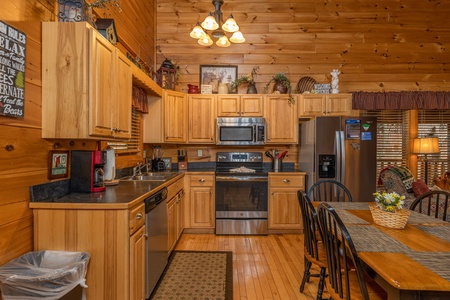 Kitchen with stainless appliances and dining table for six at Absolutely Wonderful, a 2 bedroom cabin rental located in Pigeon Forge