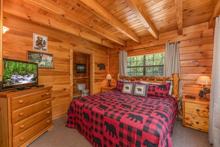 Bedroom with king bed, log furniture, dresser, and TV at Away From it All, a 1 bedroom cabin rental located in Pigeon Forge