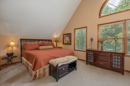 Bedroom with a king bed, two lamps, two tables, and a dresser at Amazing Memories, a 3 bedroom cabin rental located in Pigeon Forge