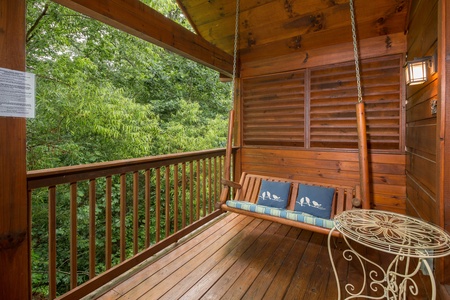 Porch swing on a covered deck at Kelly's Cabin, a 1 bedroom cabin rental located in Pigeon Forge