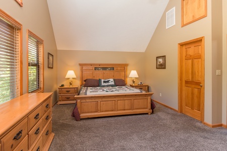 Bedroom with king bed, night stands, lamps, and a dresser at Stones Throw, a 4 bedroom cabin rental located in Pigeon Forge