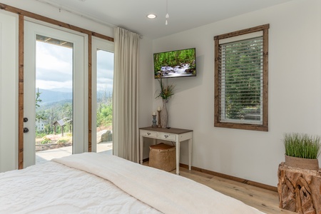 TV, table, and deck access in a bedroom at Mountain Celebration, a 4 bedroom cabin rental located in Gatlinburg