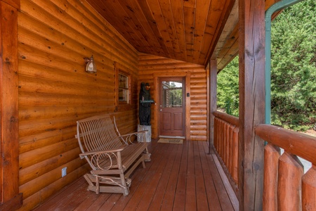 Gliding loveseat on the covered deck at Cabin Fever, a 4-bedroom cabin rental located in Pigeon Forge