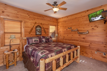 Bedroom with a king-sized log bed and TV at Great View Lodge, a 5-bedroom cabin rental located in Pigeon Forge