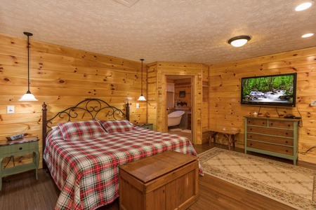 King bed with night stands, trunk, dresser, and TV at Rustic Ranch, a 2 bedroom cabin rental located in Pigeon Forge