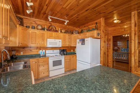Kitchen with white appliances at Hickernut Lodge, a 5-bedroom cabin rental located in Pigeon Forge