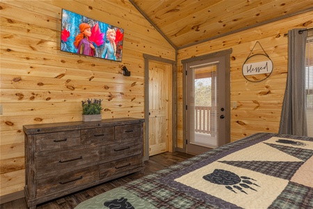 Dresser and TV in a bedroom with deck access at Everly's Splash, a 4 bedroom cabin rental located in Pigeon Forge
