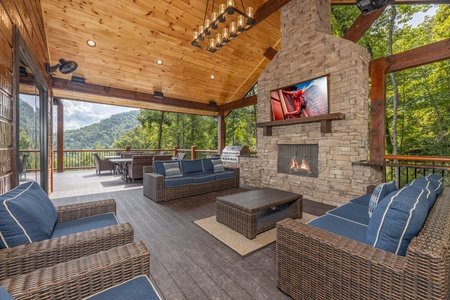Outdoor seating area with a fireplace and TV at Black Bears & Biscuits Lodge, a 6 bedroom cabin rental located in Pigeon Forge