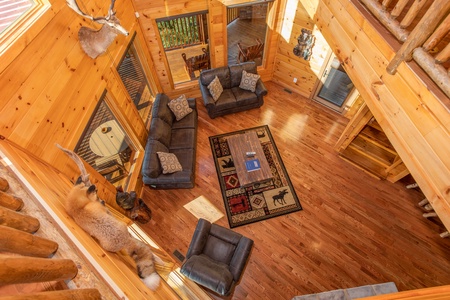 Sofa, loveseat, and chair in the living room as viewed from the upper floor at Four Seasons Palace, a 5-bedroom cabin rental located in Pigeon Forge