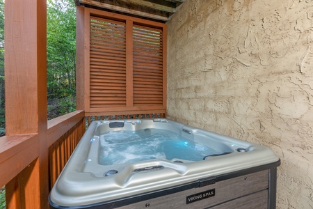 Hot tub on a covered porch at Southern Charm, a 2 bedroom cabin rental located in Pigeon Forge