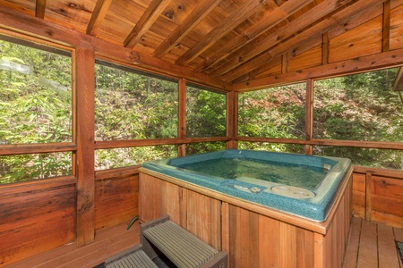 Hot tub on a covered porch at Eagle's Loft, a 2 bedroom cabin rental located in Pigeon Forge