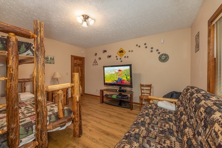Room with a bunk bed and futon at Cubs' Crib, a 3 bedroom cabin rental located in Gatlinburg