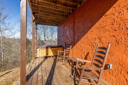 Lower deck with hot tub and rocking chairs at Nascar Nation, a 2 bedroom cabin rental located in Pigeon Forge
