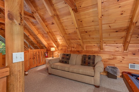 sofa seating in the game room loft space at alpine something blue a 1 bedroom cabin rental located in pigeon forge