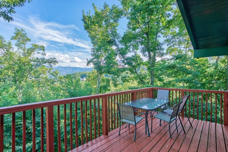 Dining space for four on the deck with mountain views at Bushwood Lodge, a 3-bedroom cabin rental located in Gatlinburg