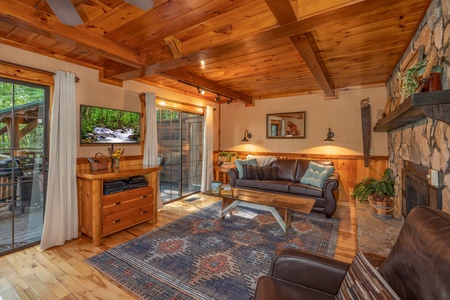 Living room with a TV and deck access at Hidden Pleasure, a 1-bedroom cabin rental located in Gatlinburg