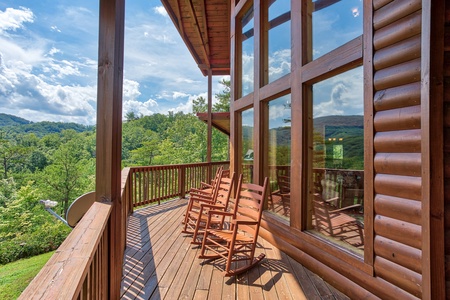 Rocking chairs on the covered deck overlooking the mountains at Four Seasons Lodge, a 3-bedroom cabin rental located in Pigeon Forge