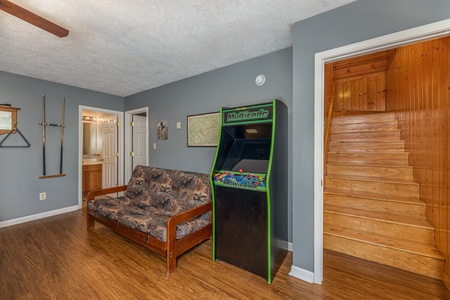 Futon and arcade game at Wildlife Retreat, a 3 bedroom cabin rental located in Pigeon Forge