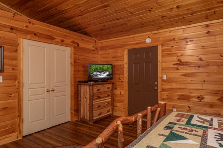 Bedroom with a dresser and TV at Hawk's Heart Lodge, a 3 bedroom cabin rental located in Pigeon Forge
