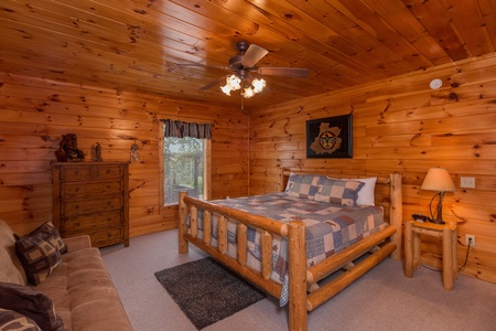 Bedroom with a king log bed, dresser, and sofa at A Beautiful Memory, a 4 bedroom cabin rental located in Pigeon Forge
