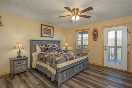 Bedroom with two night stands and lamps and deck access at Le Bear Chalet, a 7 bedroom cabin rental located in Gatlinburg